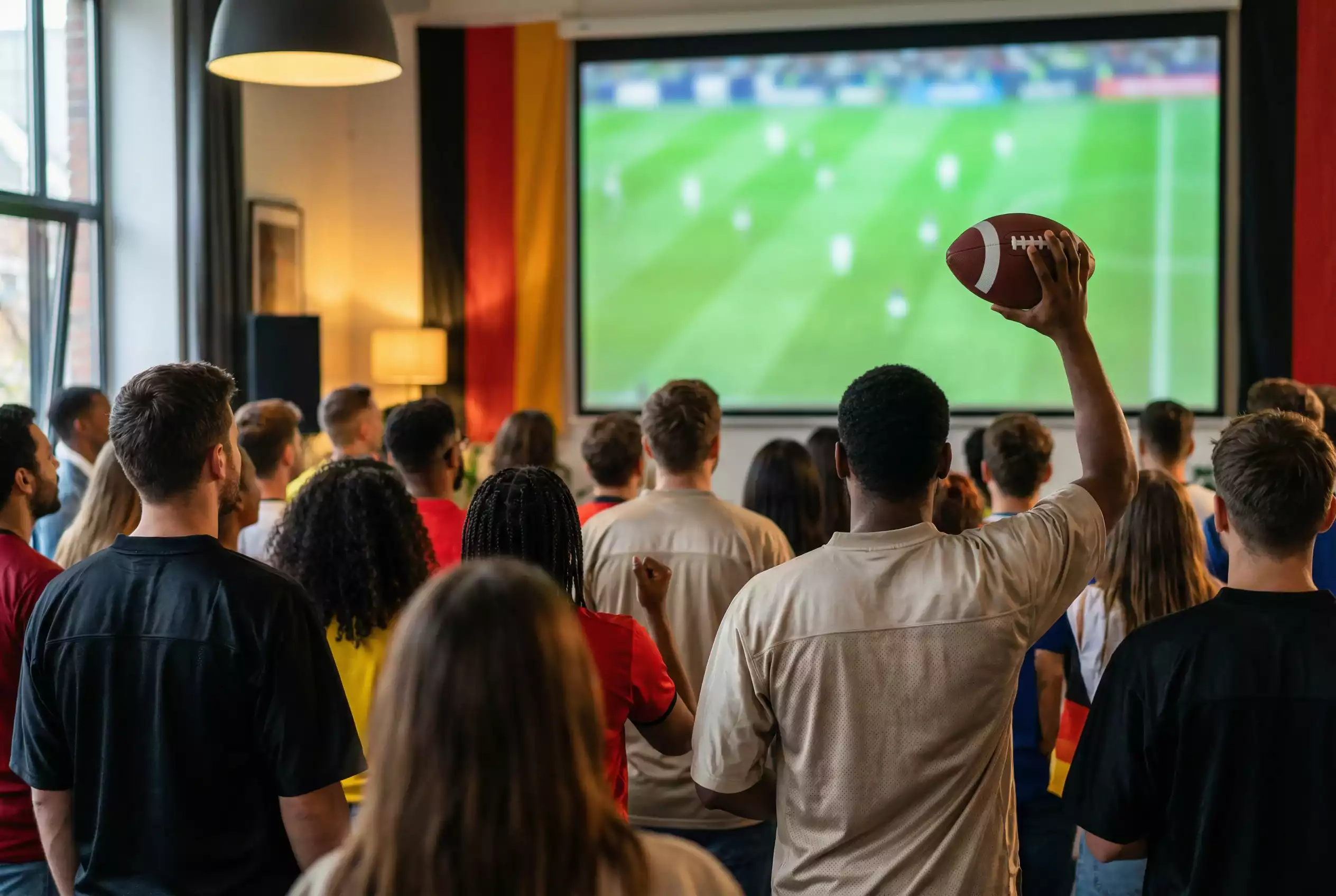 Menschenmenge mit American-Football-Ausrüstung bei einem Public Viewing
