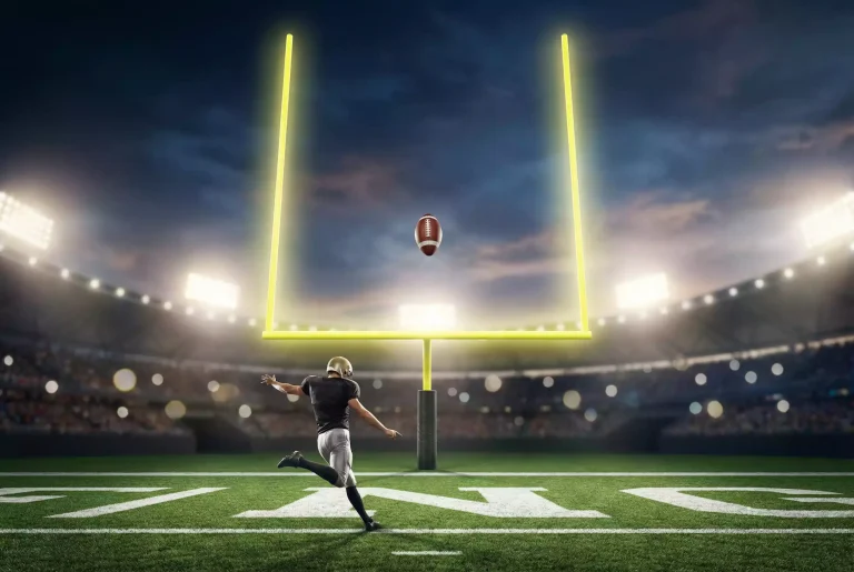 American-Football-Spieler beim Field-Goal-Kick zwischen den Torpfosten