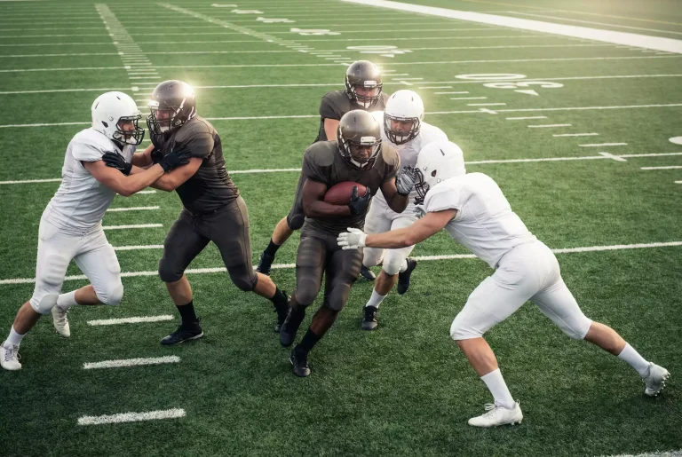 Mehrere American-Football-Spieler beim Spielzug auf dem Feld