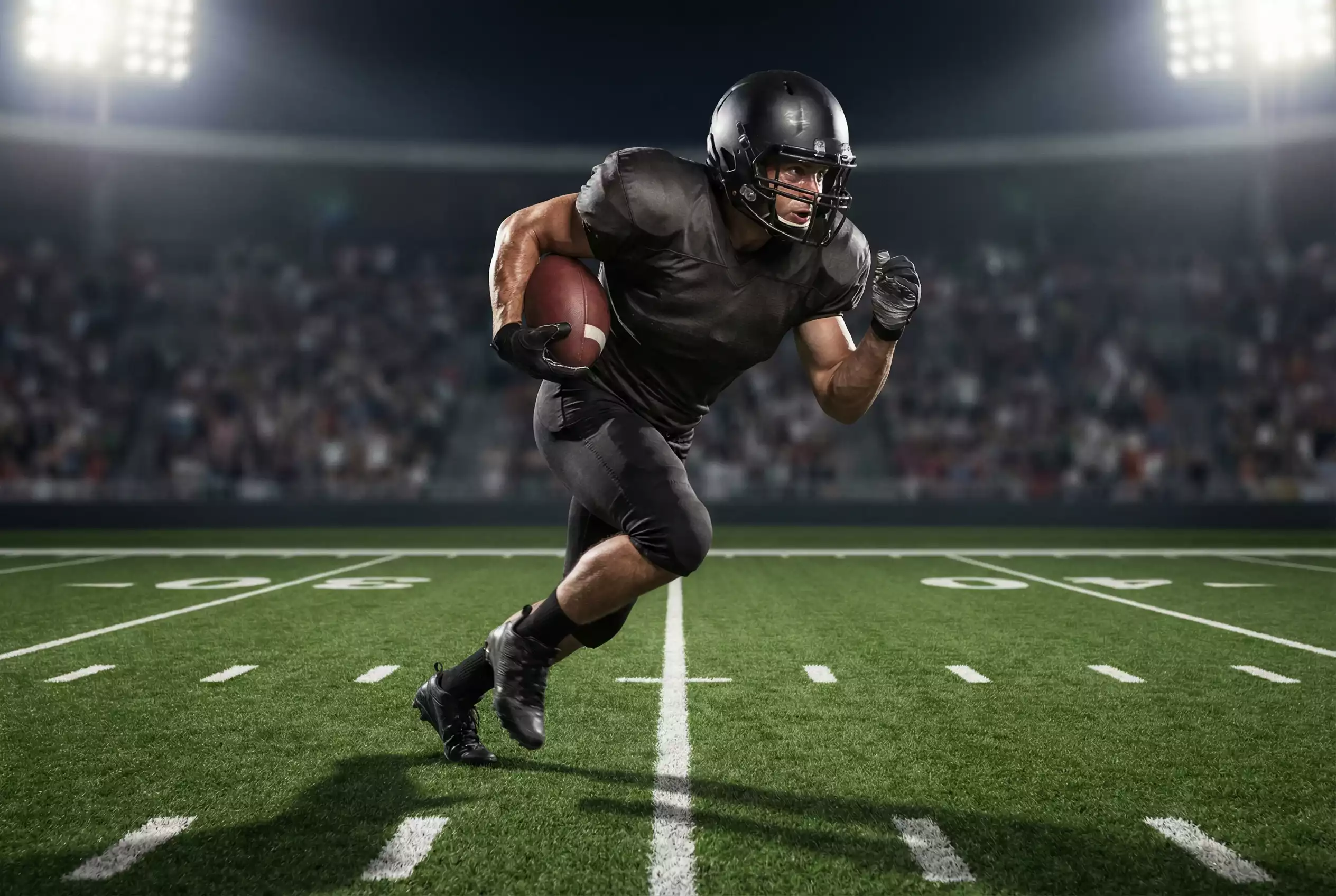 American-Football-Spieler mit Ball unter dem Arm läuft über das Feld