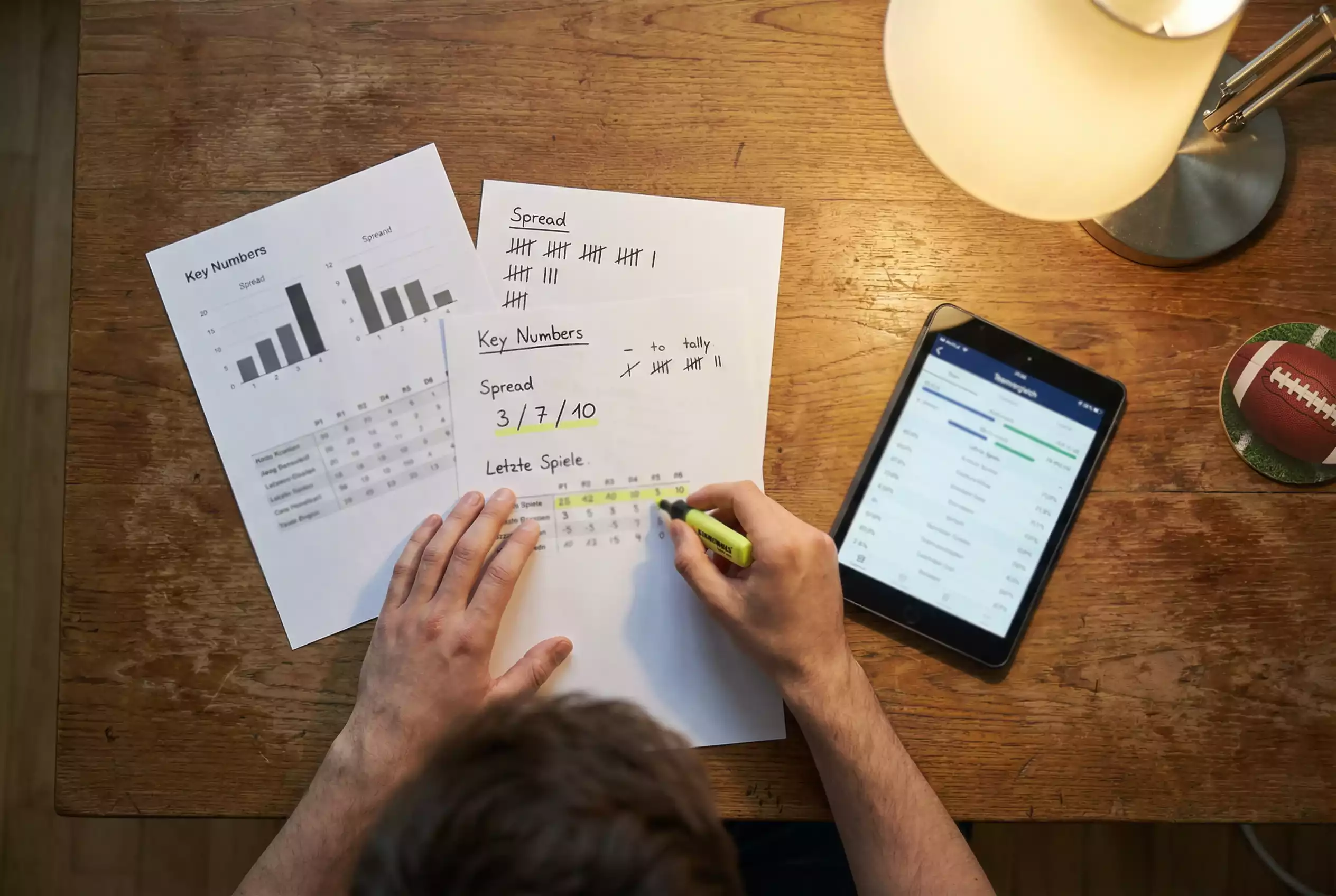 NFL Wetten Strategien — Person analysiert Footballstatistiken auf Papiernotizen
